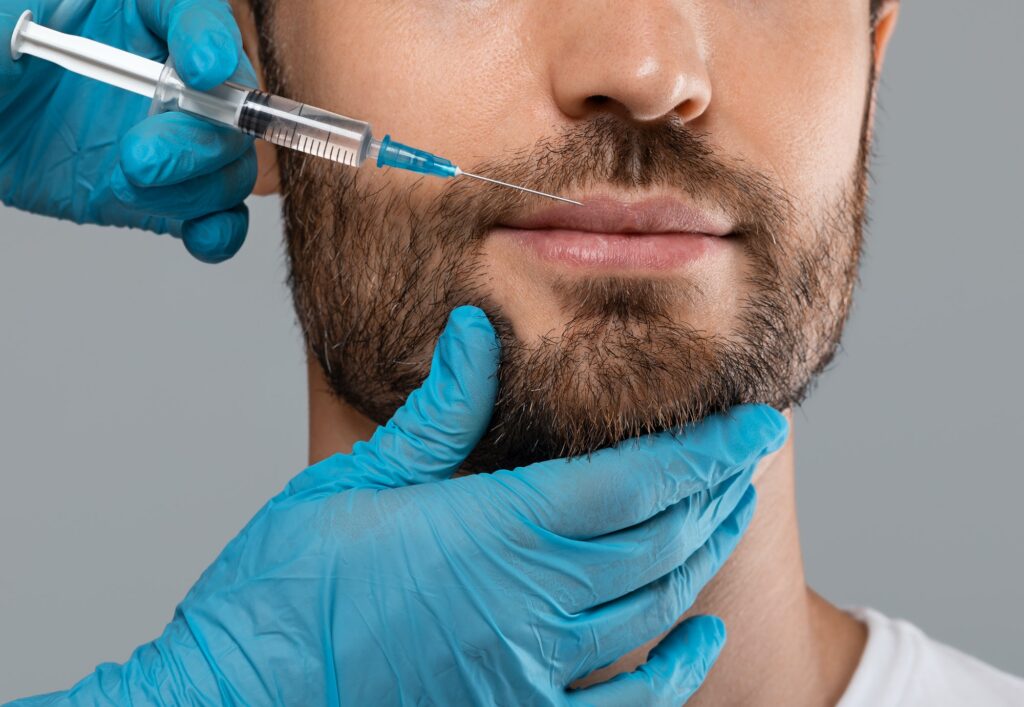 Unrecognizable bearded man getting lips filler in beauty salon